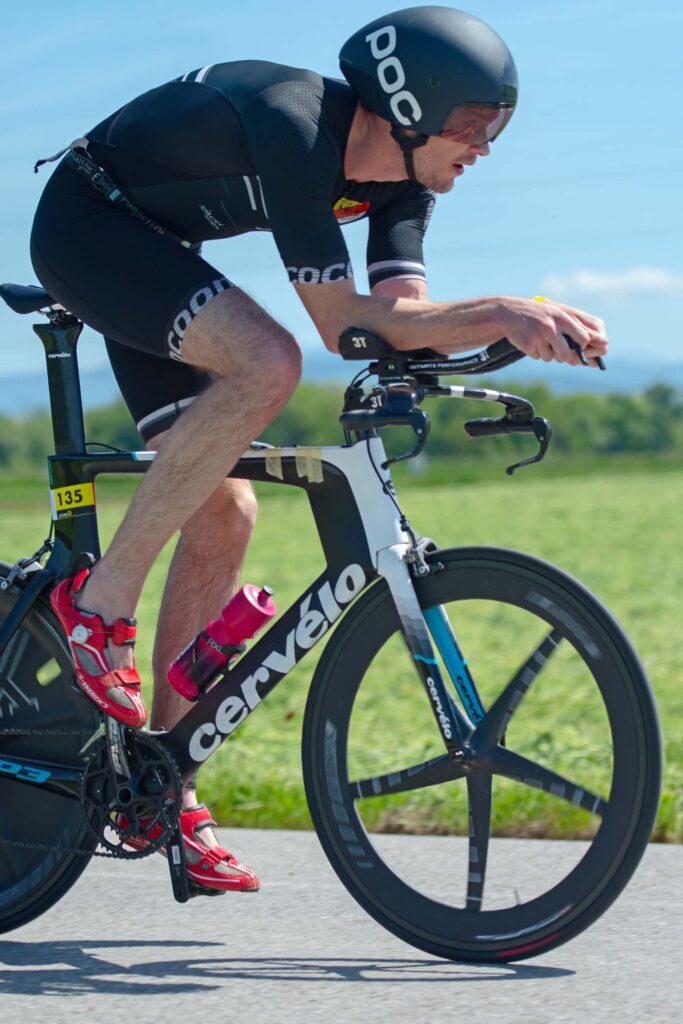 Massimo Köstl-Lenz als Triathlon Trainer in stabiler Aeroposition auf dem Zeitfahrrad während eines Triathlons.