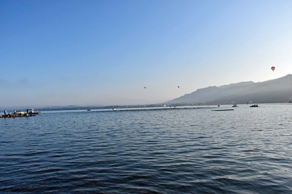 Massimo Köstl-Lenz als Triathlon Sportler und Trainer beim Schwimmabschnitt des Trans Vorarlberg Triathlons am Bodensee in Bregenz im ruhigen Morgenlicht.