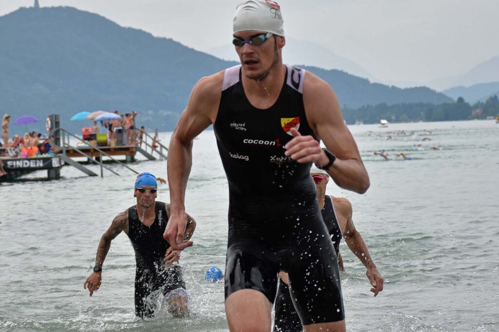 Massimo Köstl-Lenz kommt beim Triathlon am Wörthersee als einer der ersten Athleten aus dem Wasser und sprintet vom Schwimmausstieg an Land.