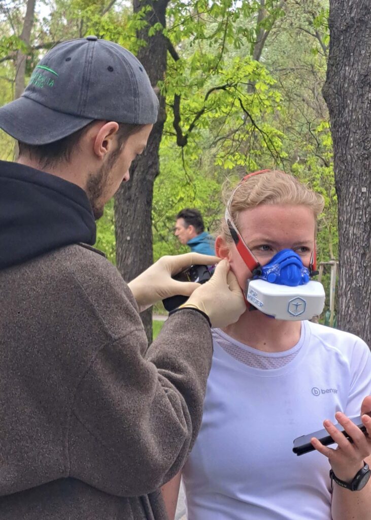 Massimo Köstl-Lenz misst bei einer Sportlerin mit VO2-Master-Maske nach der Belastung das Laktat im Rahmen der mobilen Laufdiagnostik.