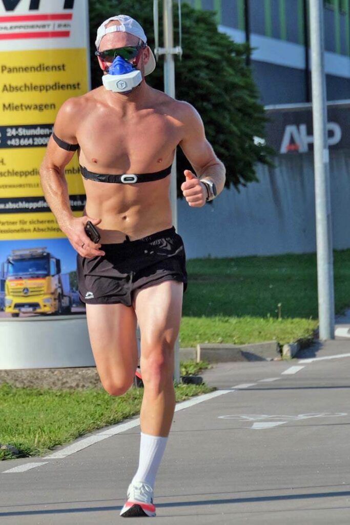 Mobile Leistungsdiagnostik im Triathlon: Ein Sportler läuft mit VO2-Master-Maske unter realen Bedingungen.